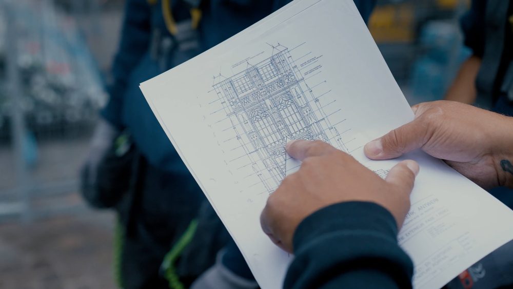 Blueprint of Antwerp Cathedral renovations, featured in a PuraVideos promo and explainer video for Confederatiebouw België highlighting construction process, safety, and skilled workforce
