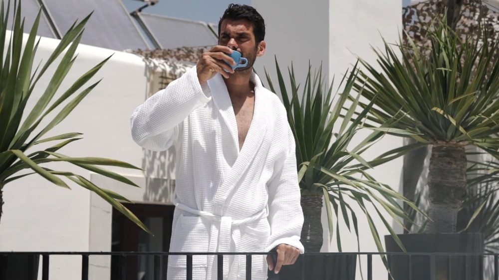 Man enjoying a coffee on the rooftop terrace of The Giri Luxury Residence, featured in a PuraVideos lifestyle film highlighting Ibiza’s luxury and relaxed atmosphere