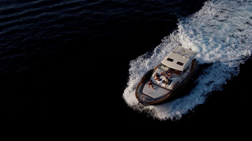Boat in front of a luxury private residence in Ibiza, featured in a PuraVideos film for Qpartner showcasing modern international living